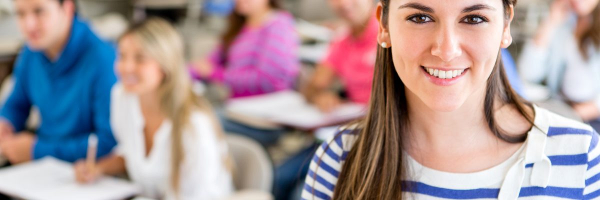 Female college student in a classroom holding a notebook